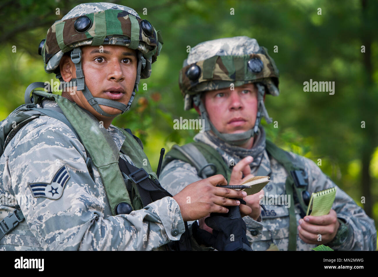 U.S. Air Force Senior Airman Sergio Frasco, left, and Staff Sgt. Farrell Bowers, both assigned to the 434th Security Forces Squadron, Grissom AFB, Ind., maneuver through the woods as they participate in a tactical engagement simulation drill during exercise Patriot Warrior at Young Air Assault Strip, Fort McCoy, Wis., Aug. 18, 2017. More than 600 Reserve Citizen Airmen and over 10,000 soldiers, sailors, Marines and international partners converged on the state of Wisconsin to support a range of interlinked exercises including Patriot Warrior, Global Medic, CSTX, Diamond Saber, and Mortuary Aff Stock Photo