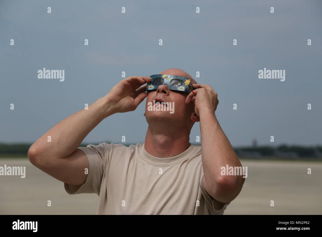 A U.S. Air Force airman from the New Jersey Air National Guard's 108th Wing watches a partial eclipse over Joint Base McGuire-Dix-Lakehurst, N.J., Aug. 21, 2017. A solar eclipse occurs when the Moon passes between Earth and the Sun, totally or partly obscuring the image of the Sun for a viewer on Earth. At Joint Base McGuire-Dix-Lakehurst, totality was approximately eighty percent coverage of the Sun. (U.S. Air National Guard photo by Master Sgt. Matt Hecht/Released) Stock Photo