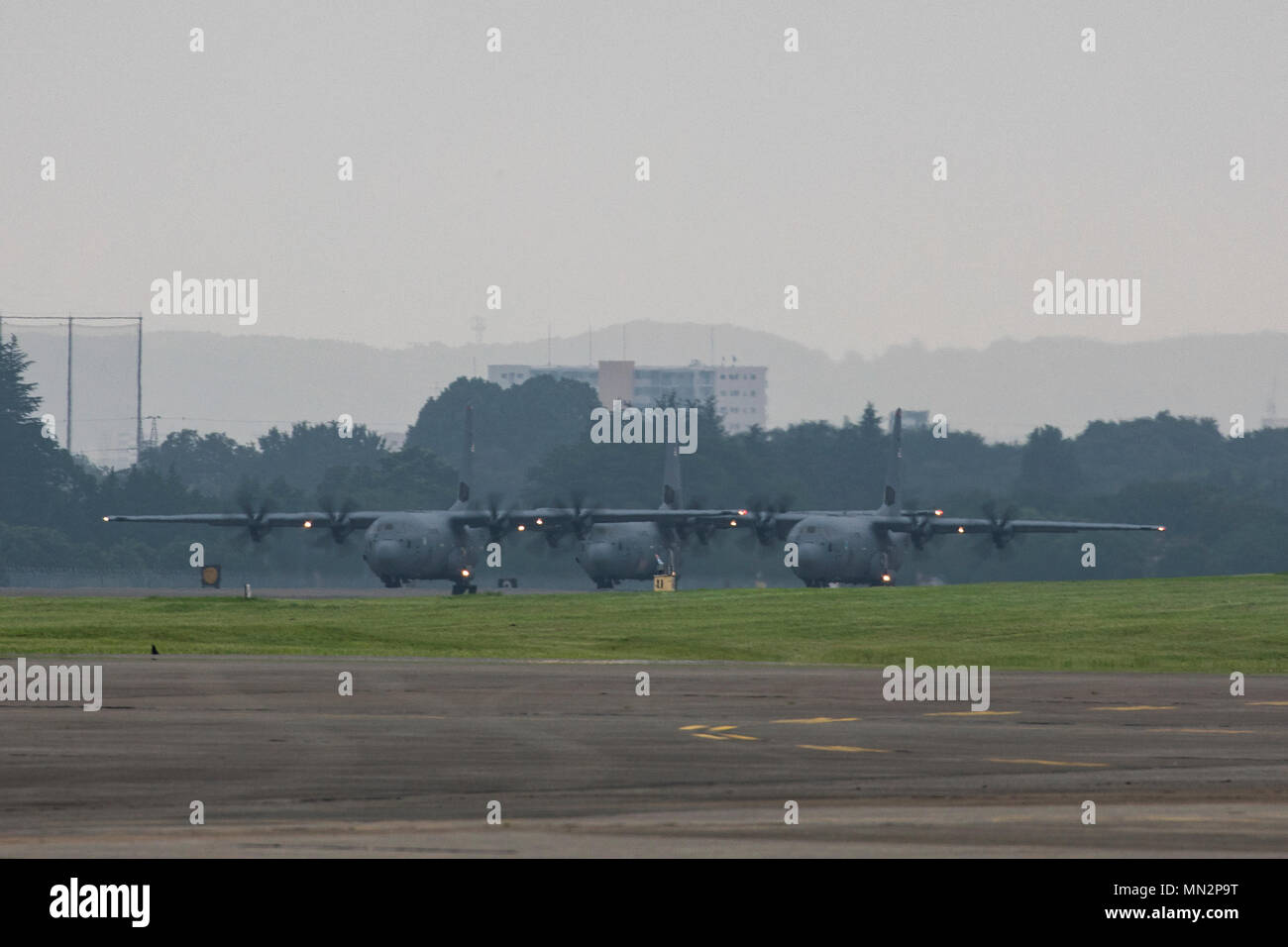 Three C-130J Super Hercules aircrafts prepare for takeoff during Exercise Beverly Morning 17-05 at Yokota Air Base, Japan, Aug. 18, 2017. The training is designed to test the ability of Airmen to survive in austere environments with chemical, biological, radiological, nuclear and explosive hazards. (U.S. Air Force photo by Yasuo Osakabe) Stock Photo