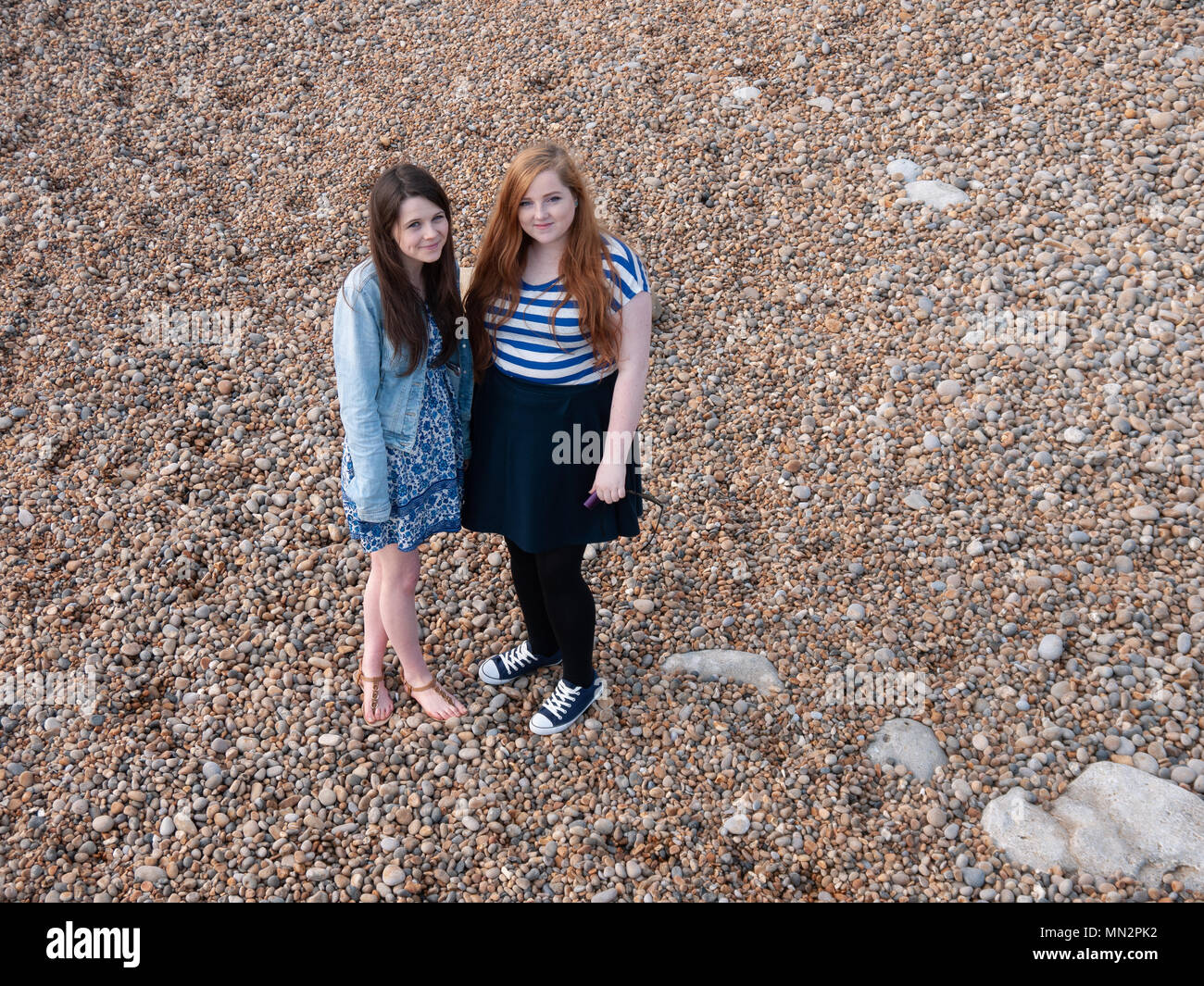 Two young ladies on a pebble beach Stock Photo