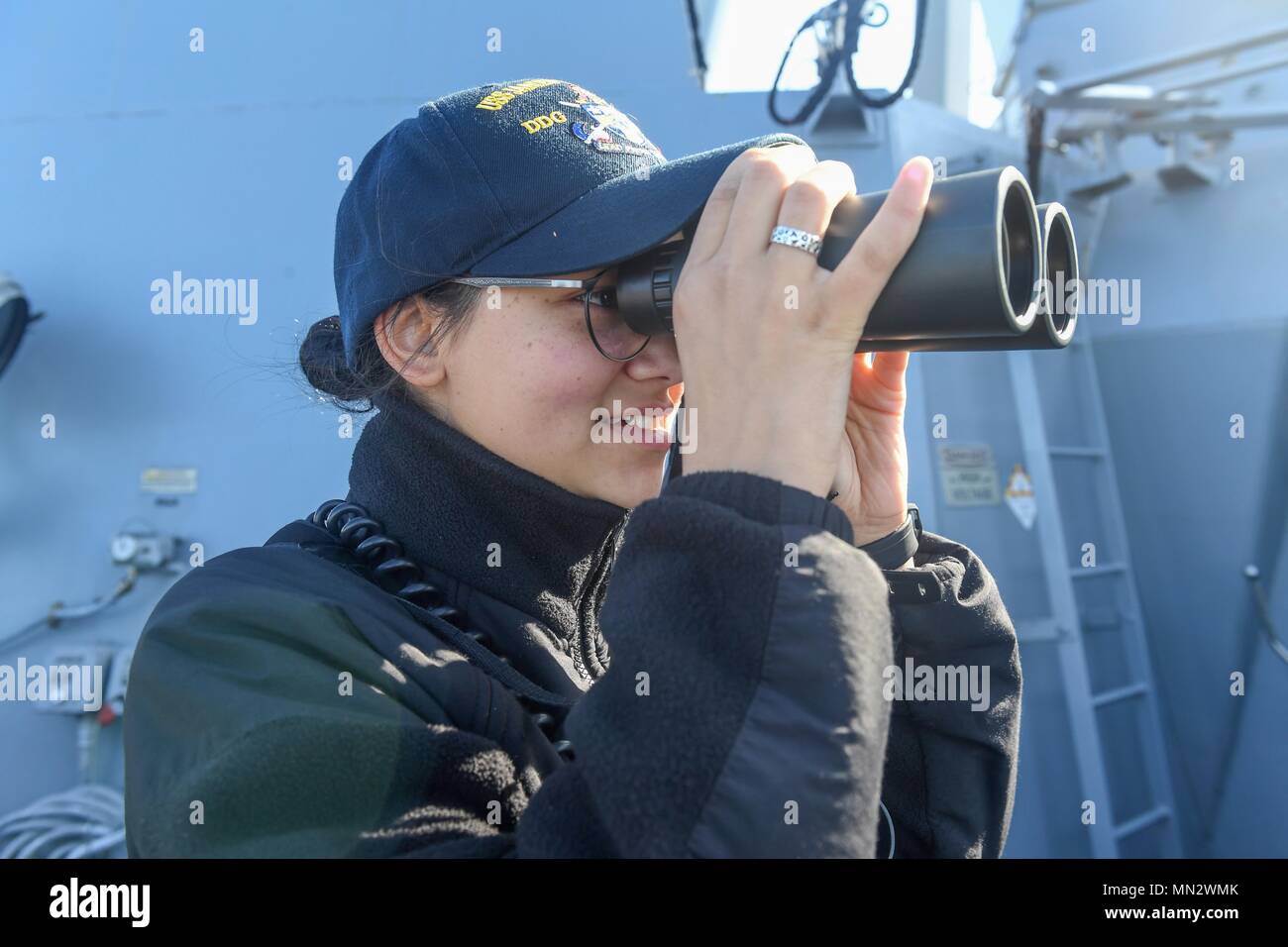 170822-N-GX781-191 SKAGERRAK STRAIT (Aug. 22, 2017) - Ensign Paris Bess, from Troy, Ohio, scans the horizon with binoculars aboard the Arleigh Burke-class guided-missile destroyer USS James E. Williams (DDG 95) as the ship transits the Skagerrak Strait Aug. 22, 2017.  James E. Williams, home-ported in Norfolk, is on a routine deployment to the U.S. 6th Fleet area of operations in support of U.S. national security interests in Europe. (U.S. Navy photo by Mass Communication Specialist 3rd Class Colbey Livingston/ Released) Stock Photo