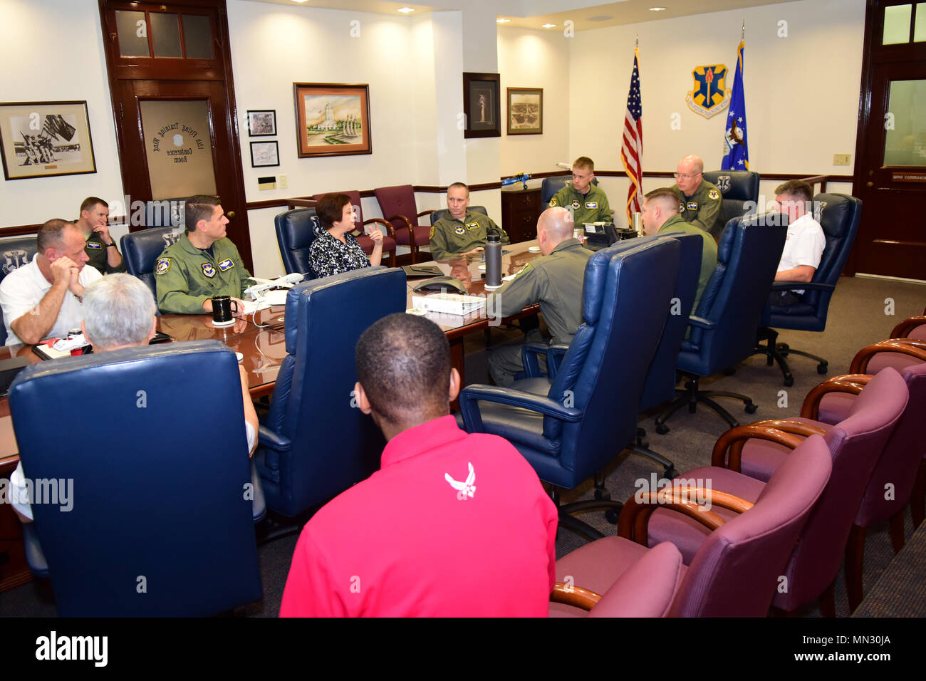 Col. Joel Carey, the 12th Flying Training Wing Commander, at the head of the table, listens to Angela Kochart, the 12th FTW's chief resource manager during an early morning senior leader team meeting August 25, 2017 at Joint Base San Antonio-Randolph, Texas.  Carey convened the meeting ahead of Hurricane Harvey's arrival on the Texas coast. Stock Photo