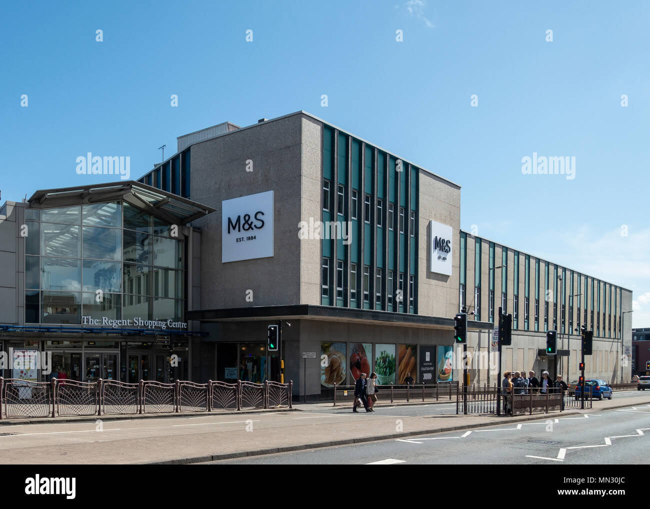 Pedestrians and shoppers in the street outside the exterior of the Marks and Spencers shop and the main entrance to Regent Shopping Centre, Hamilton Stock Photo