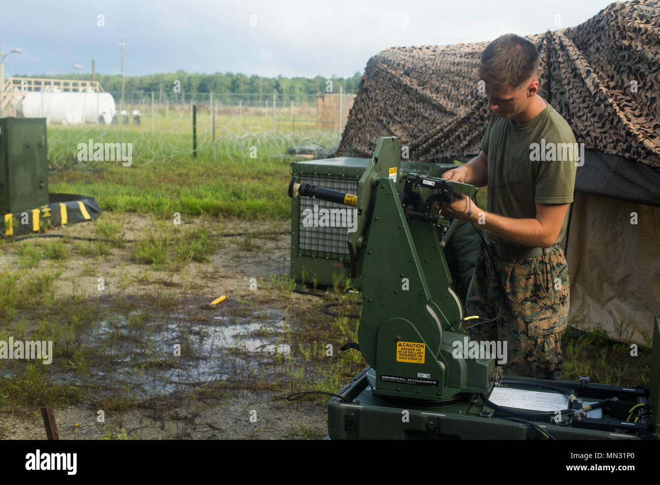 U.S. Marine Corps Cpl. Chance A. Feller, a radio operator with Combat  Logistics Battalion (CLB) 26, 26th Marine Expeditionary Unit (MEU),  attaches wires to a Very Small Aperture Terminal Small (VSAT-S) during