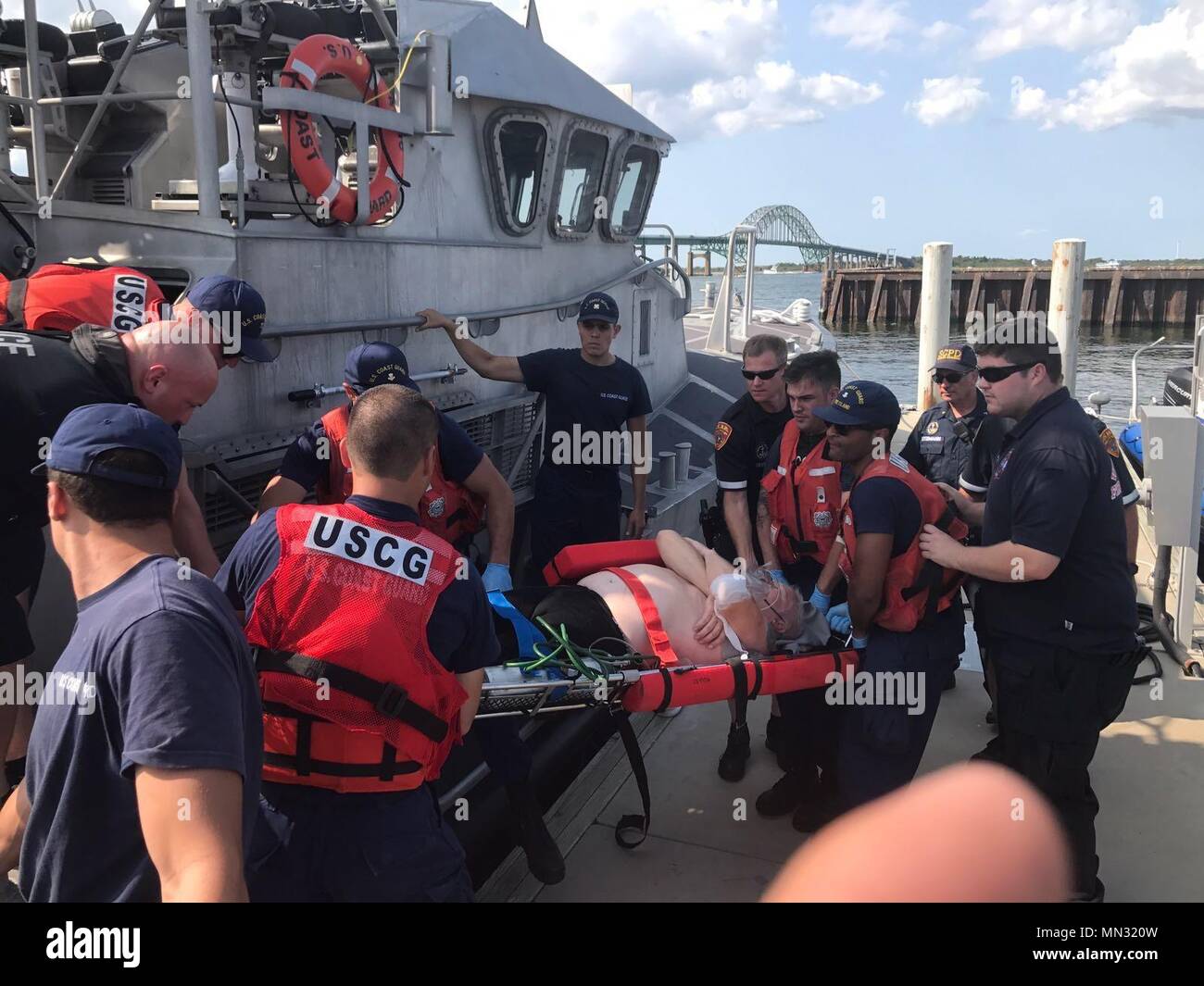 NEW YORK - Crews from Coast Guard Station Fire Island and EMT personnel from Suffolk County conduct a medevac of a man in Babylon, New York, on August 26, 2017. The man was diving 20 miles southeast of the Fire Island Inlet when he surfaced and had symptoms characteristic of the bends. (U.S. Coast Guard photo courtesy of Station Fire Island) Stock Photo