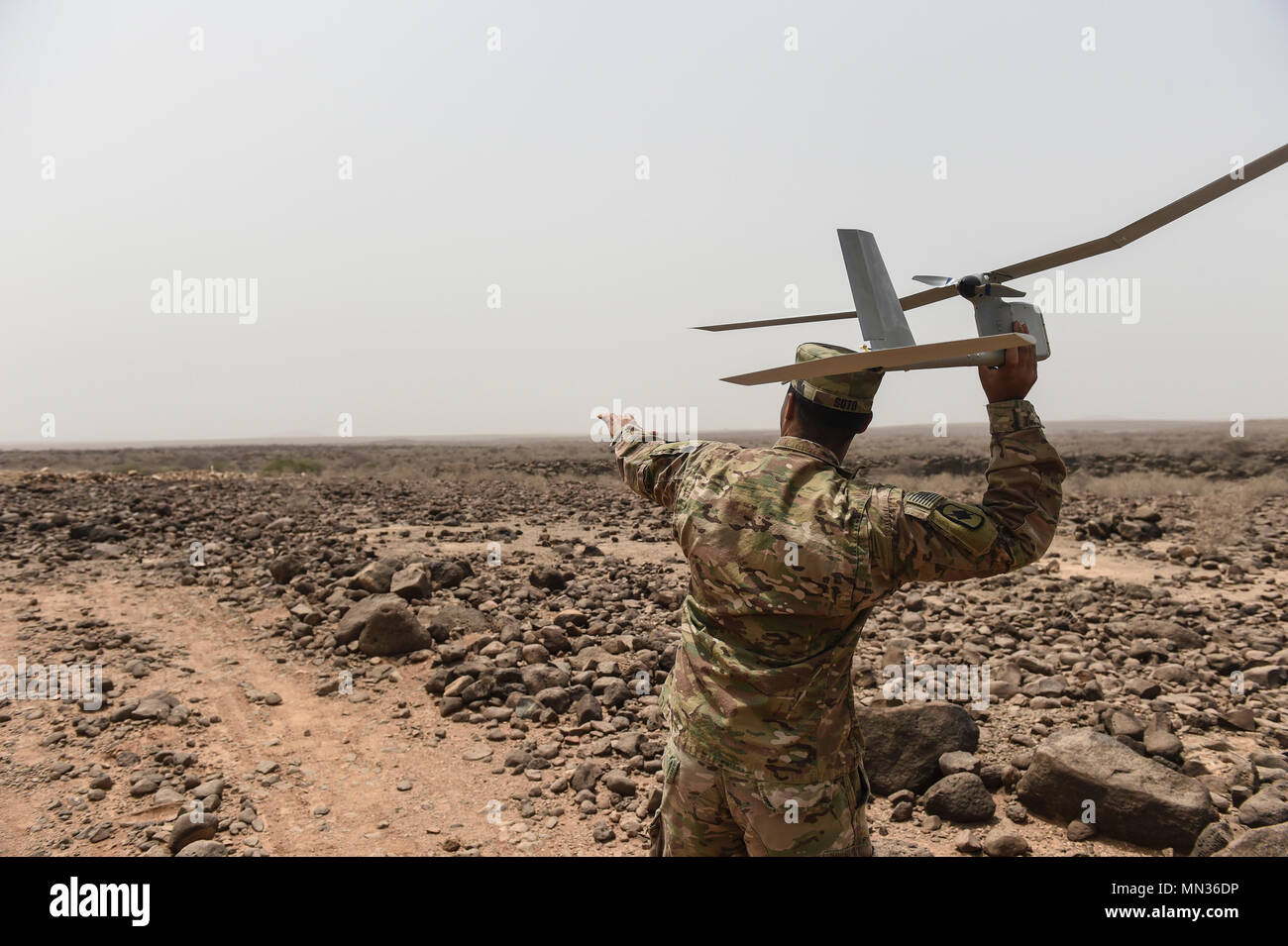 U.S. Army Spc. Enrique Soto, assigned to the 1st Battalion, 153rd Infantry Regiment, Task Force Warrior, an associated unit of Combined Joint Task Force - Horn of Africa, demonstrates a hand launch of a RQ-11 Raven remotely piloted aircraft in an airfield in southern Djibouti, Aug. 21, 2017. The demonstration was an effort to familiarize Djibouti Armed Forces members with the unmanned aerial vehicle system, clear up confusion about the Raven and other RPAs, and show the safe operation of the Raven. (U.S. Air Force photo by Staff Sgt. Eboni Prince) Stock Photo