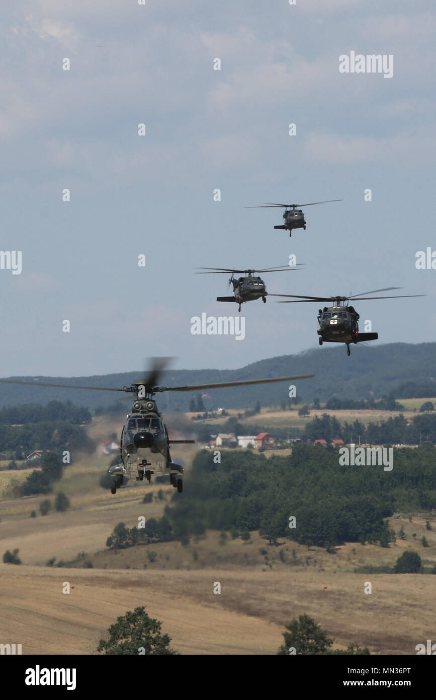 Swiss aviators in an AS332 Puma followed by UH-60 Black Hawks piloted by  KFOR Multinational Battle Group-East Southern Command Post Aviators fly in  formation over Camp Bondsteel, Kosovo, for Operation Mixed Multi-ship,