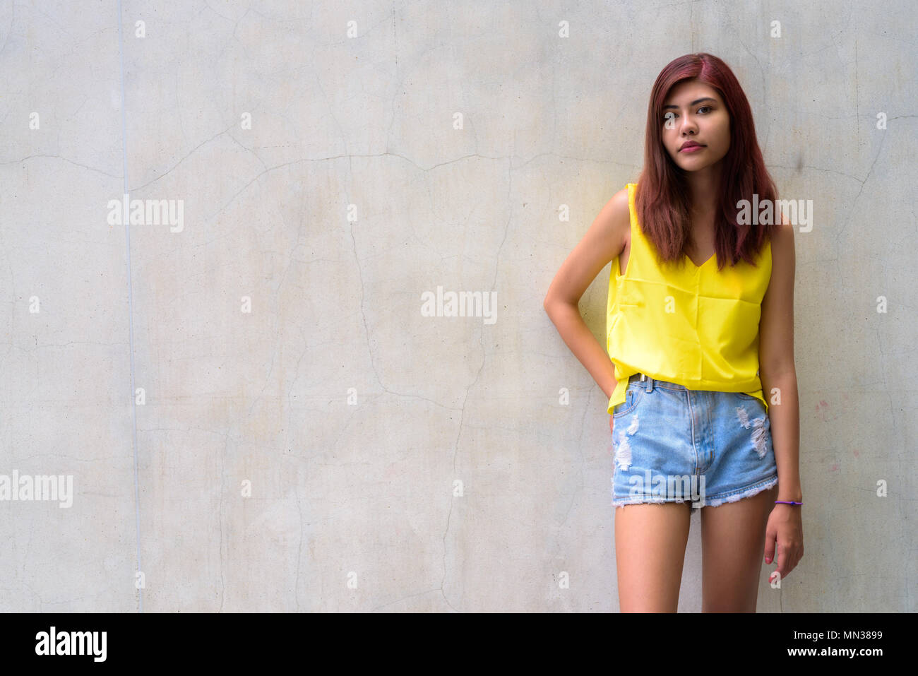 Beautiful teenager girl wearing vibrant yellow shirt Stock Photo