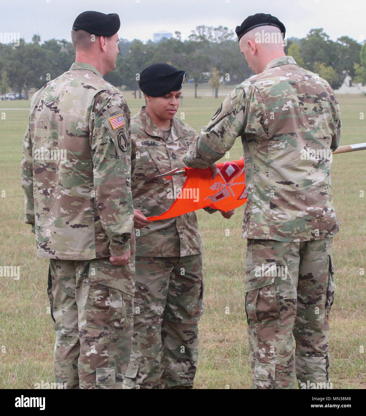 FORT GORDON, GA – Col. Chris O’Connor (left), commander, 35th Theater Tactical Signal Brigade, Capt. CPT Clayton E. Mosley (right), commander, 518th TIN Company and Master Sgt. Patrice Shuler (center), senior enlisted advisor, 518th TIN Company, furl the company guidon during the 518th Deactivation Ceremony held 31 August at Barton Field’s Reviewing Stand. (U.S. Army photo by Sgt. Victor Everhart Jr.) Stock Photo