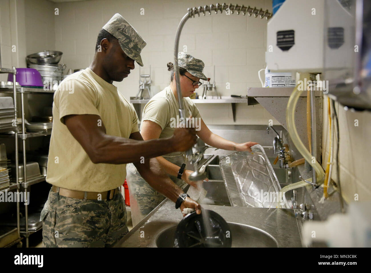 Staff Sgt. Thomas Rucker, a 147th Force Support Squadron fitness monitor, and Airman 1st Class Mandy Cantu, a 147th FSS food service specialist, wash pots and pans after lunch in the dining facility at Ellington Field Joint Reserve Base, Texas, Sept. 3, 2017. Members of the FSS at Ellington Field have been working more than ten hours each day, and seven days a week at the dining facility to provide meals to service members. (Air National Guard photos by Staff Sgt. Daniel J. Martinez) Stock Photo