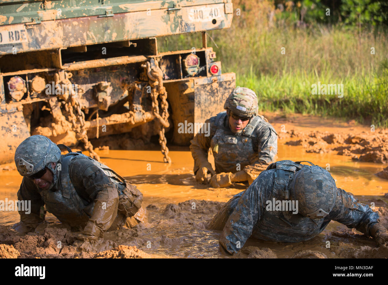 U.S. Soldiers, assigned to 215th Brigade Support Battalion, 1st Cavalry Division, walk through the mud at the Maintenance Recovery Site event during the Ordnance Crucible at Fort Pickett, Va., Aug. 23, 2017. The U.S. Army Ordnance Crucible is a three-part competition, comprised of the Ammunition Transfer Holding Point, Combat Repair Team, and Explosive Ordnance Disposal, which is designed to test Soldiers’ teamwork and critical thinking skills. (U.S. Army photo by Pfc. Dracorius White) Stock Photo