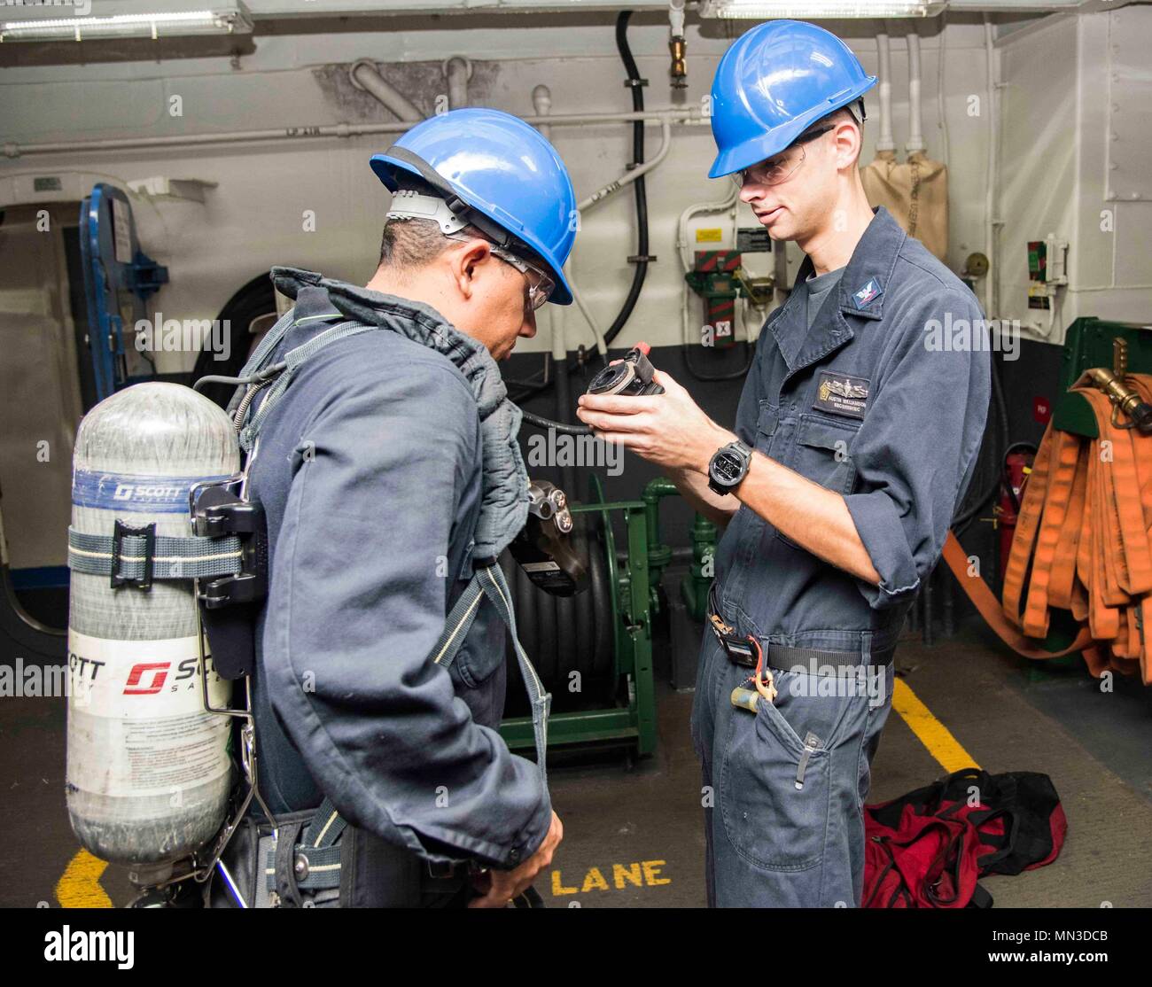 170824-N-LN243-026   PORTSMOUTH, Va. (Aug. 24, 2017) Damage Controlman 3rd Class Austin Williamson, from Loganville, Ga., right, and Cryptologic Technician (Collection) 3rd Class Norman Laureanomiranda, from San Juan, Puerto Rico, left, practice putting on a self-contained breathing apparatus aboard the aircraft carrier USS Dwight D. Eisenhower (CVN 69)(Ike). Ike is preparing for a Planned Incremental Availability (PIA) at Norfolk Naval Shipyard during the maintenance phase of the Optimized Fleet Response Plan (OFRP)  (U.S. Navy photo by Mass Communication Specialist Seaman Marques M. Franklin Stock Photo