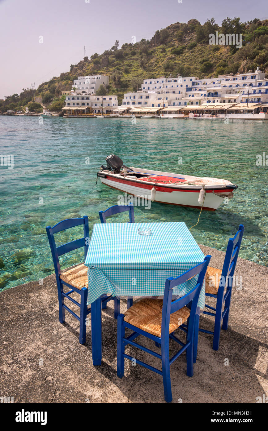 Restaurant tables by the sea in the scenic village of Loutro  in Crete, Greece Stock Photo
