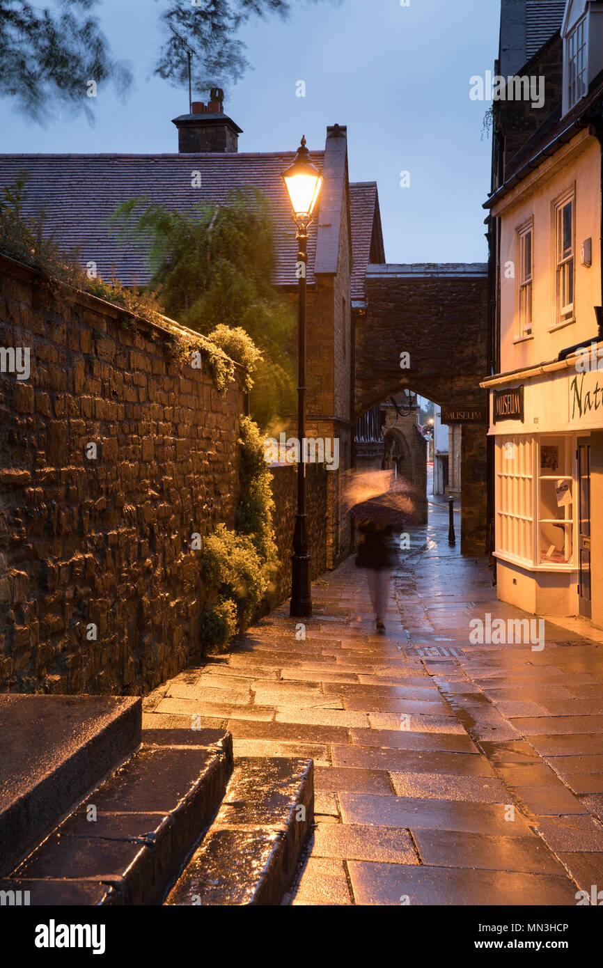 Woman in the rain on a summer evening, Sherborne, Dorset, England, UK Stock Photo