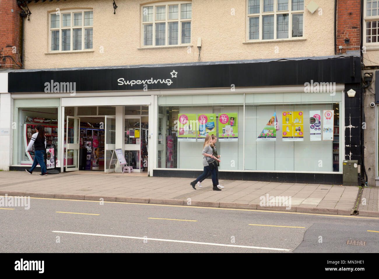 People walking past a Superdrug store in Hitchin town centre, Hertfordshire, England Stock Photo