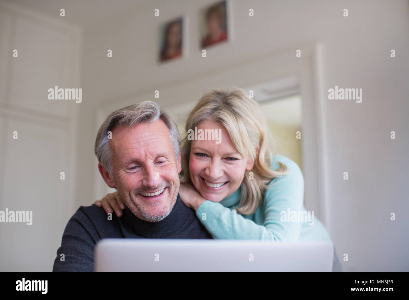 Smiling, happy mature couple using laptop Stock Photo