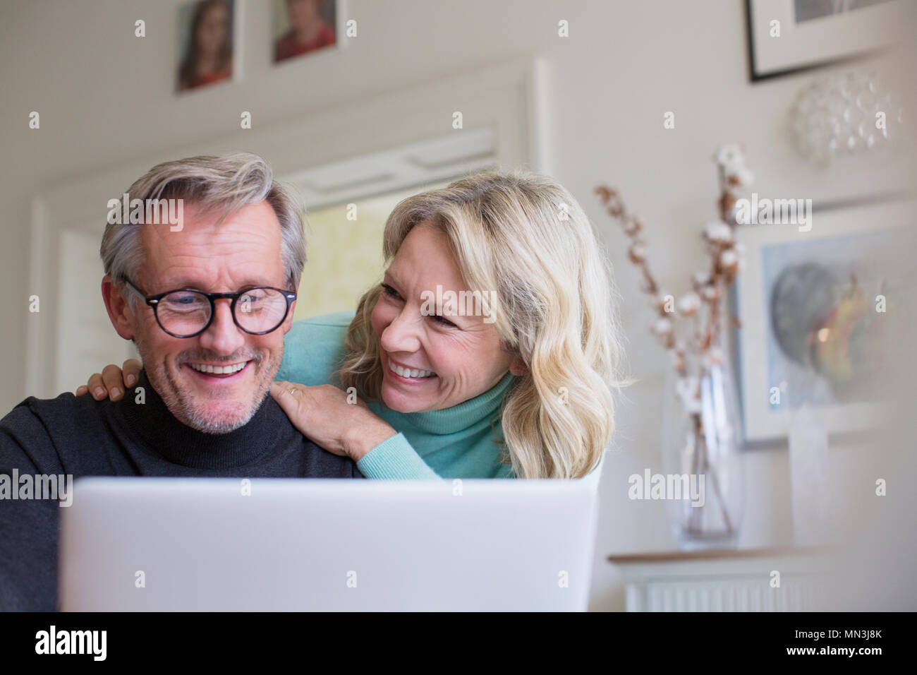Smiling mature couple using laptop Stock Photo
