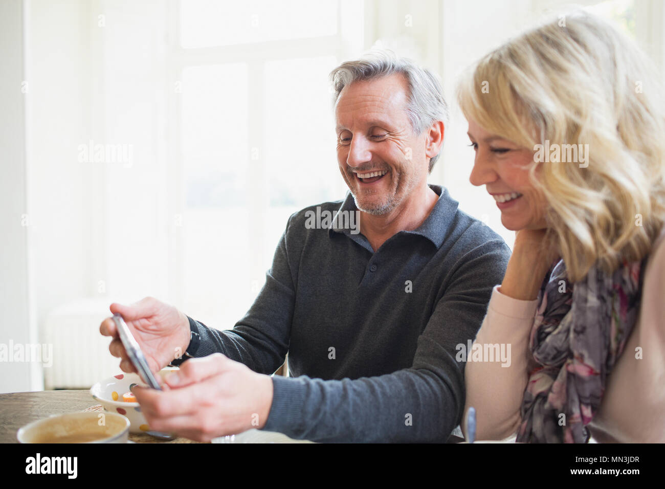 Smiling mature couple using smart phone Stock Photo
