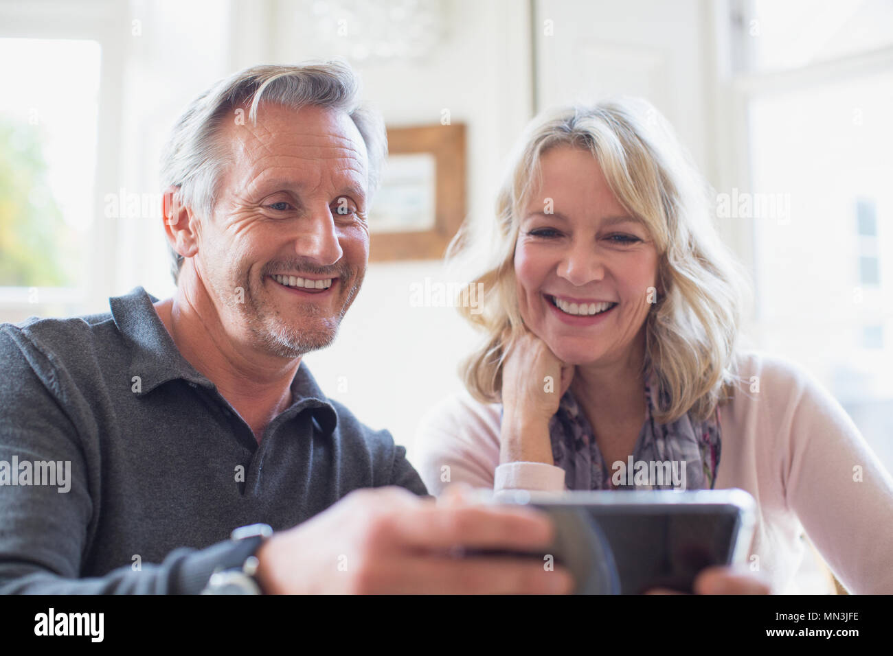 Smiling mature couple using smart phone Stock Photo