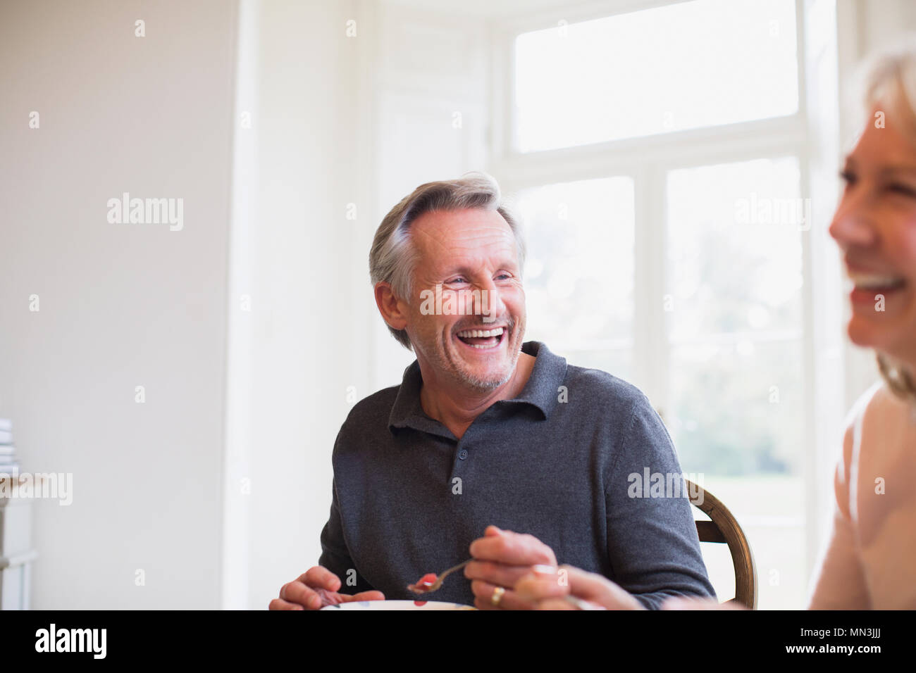 Laughing mature couple eating Stock Photo