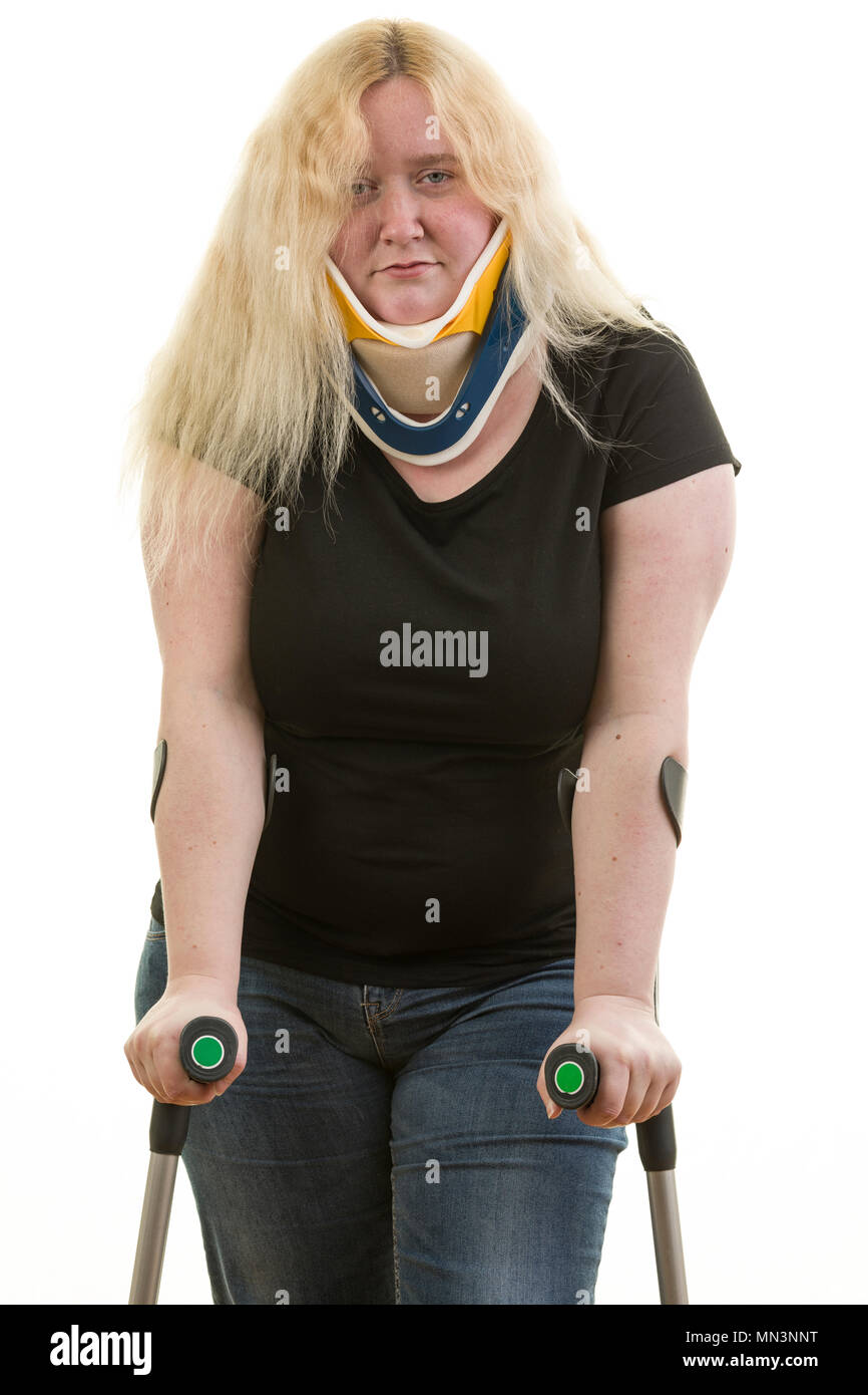 Injured young caucasian blonde female woman looking downcast using crutches isolated on white background  Model Release: Yes. Property Release: No. Stock Photo