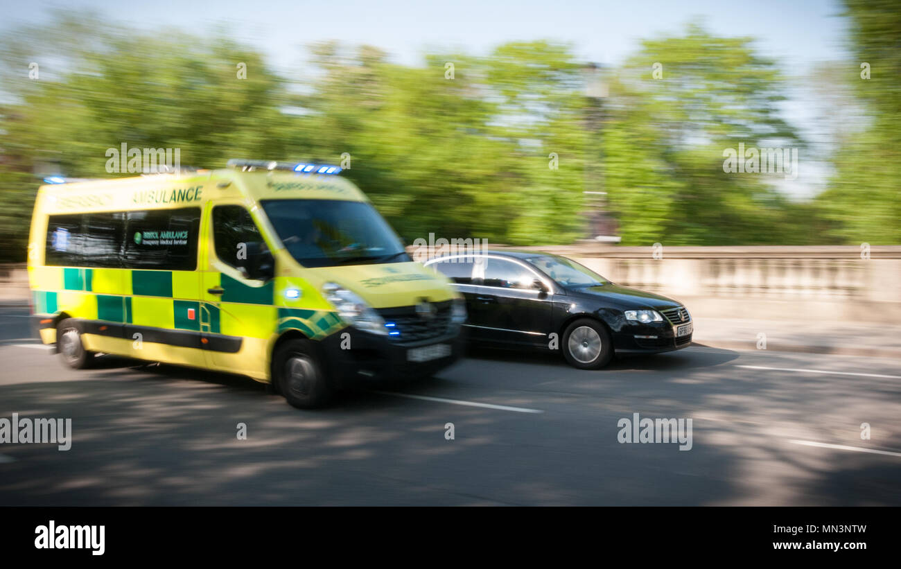 Emergency ambulance overtaking a car in traffic Stock Photo