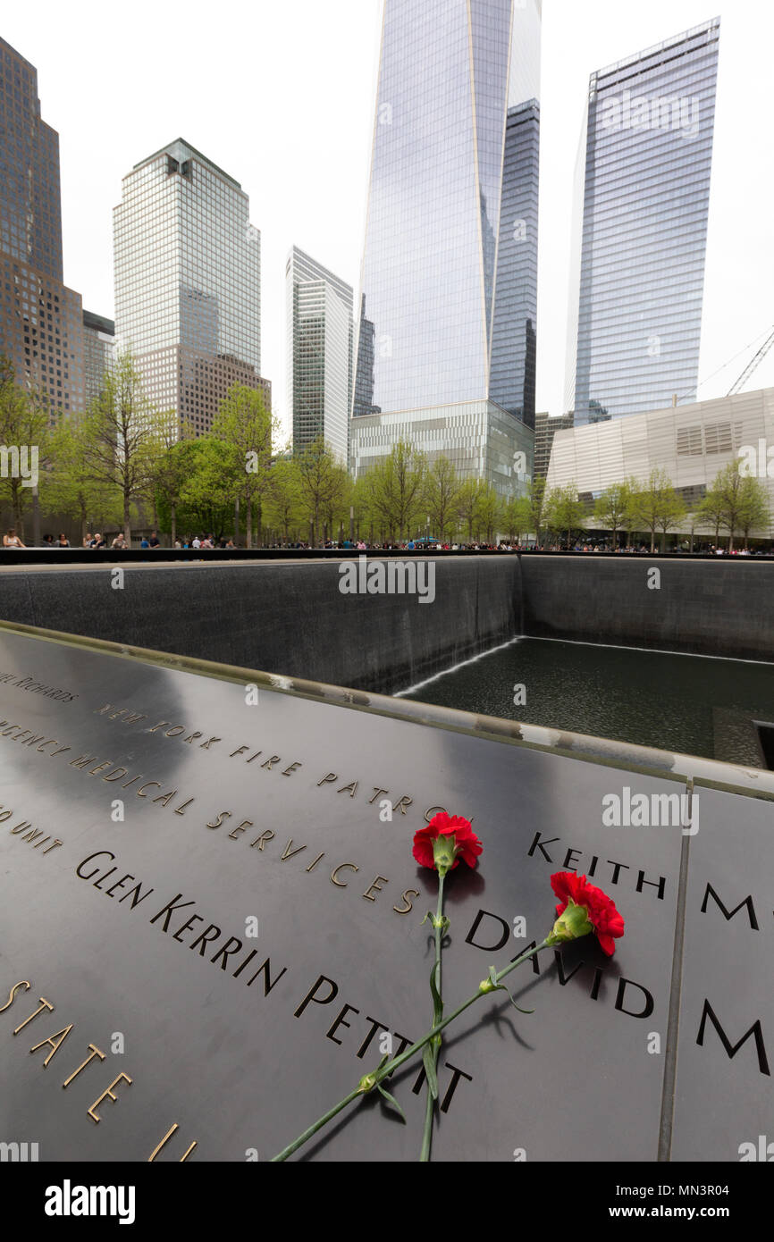 Flowers left in tribute to the victims of the 11 September 2001 attack; The 9/11 Memorial pools, downtown New York, New York city USA Stock Photo
