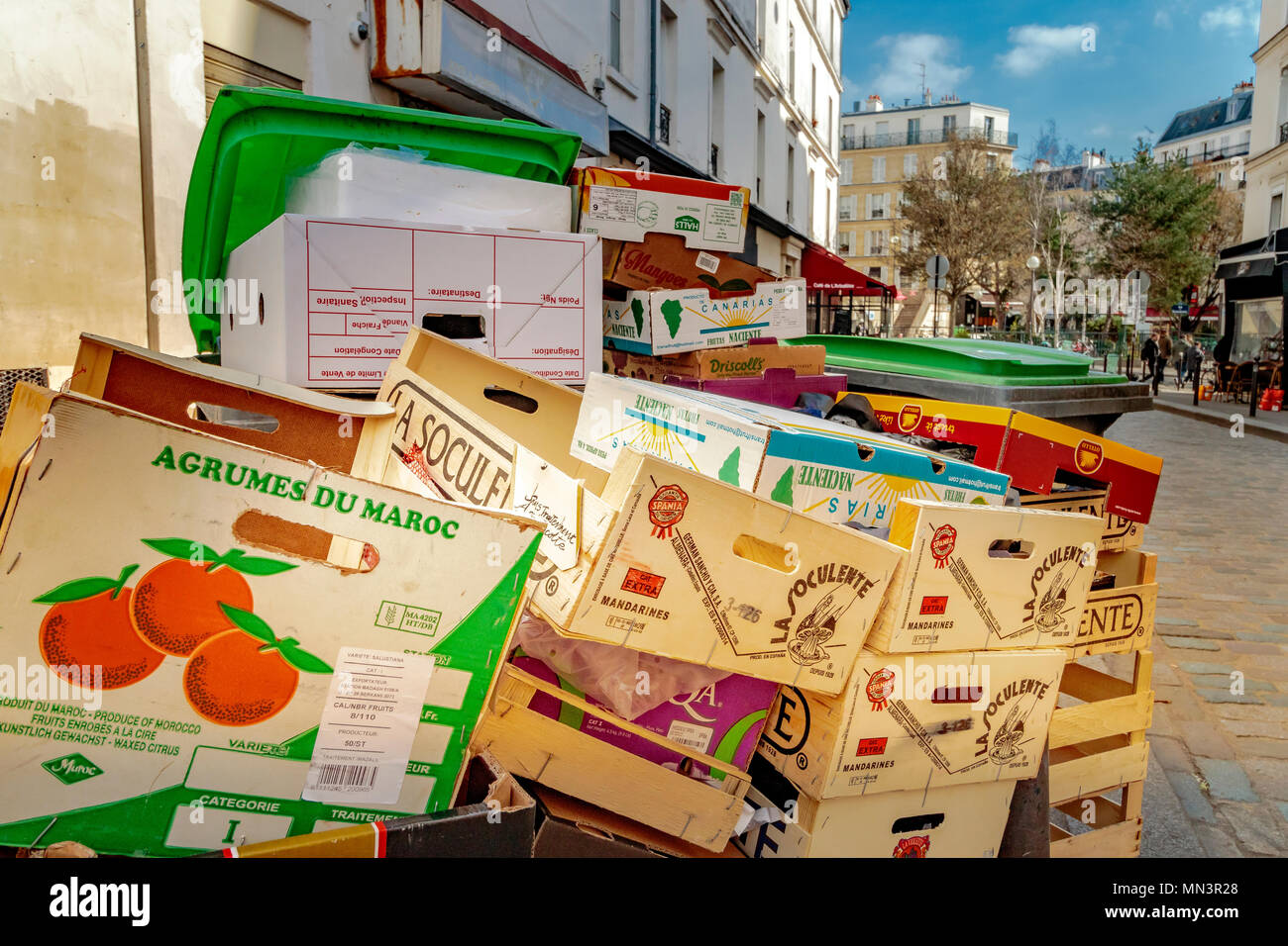 Wooden fruit boxes ,wheely bins and other cardboard boxes  piled up in by the side of Rue Mouffetard a street  in Paris, France Stock Photo