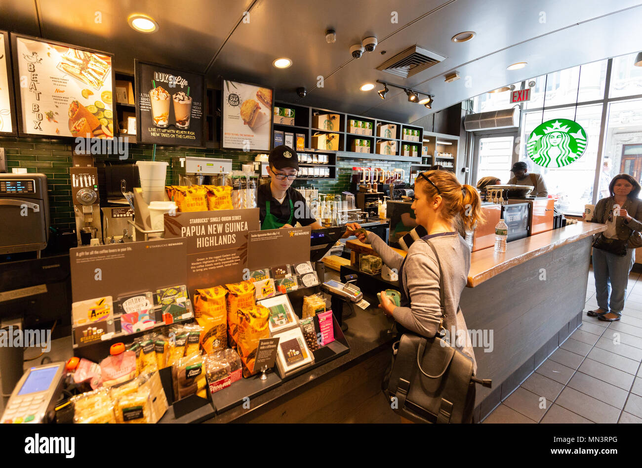 A woman buying coffee in Starbucks, Bowling Green, downtown, New York City,  USA Stock Photo