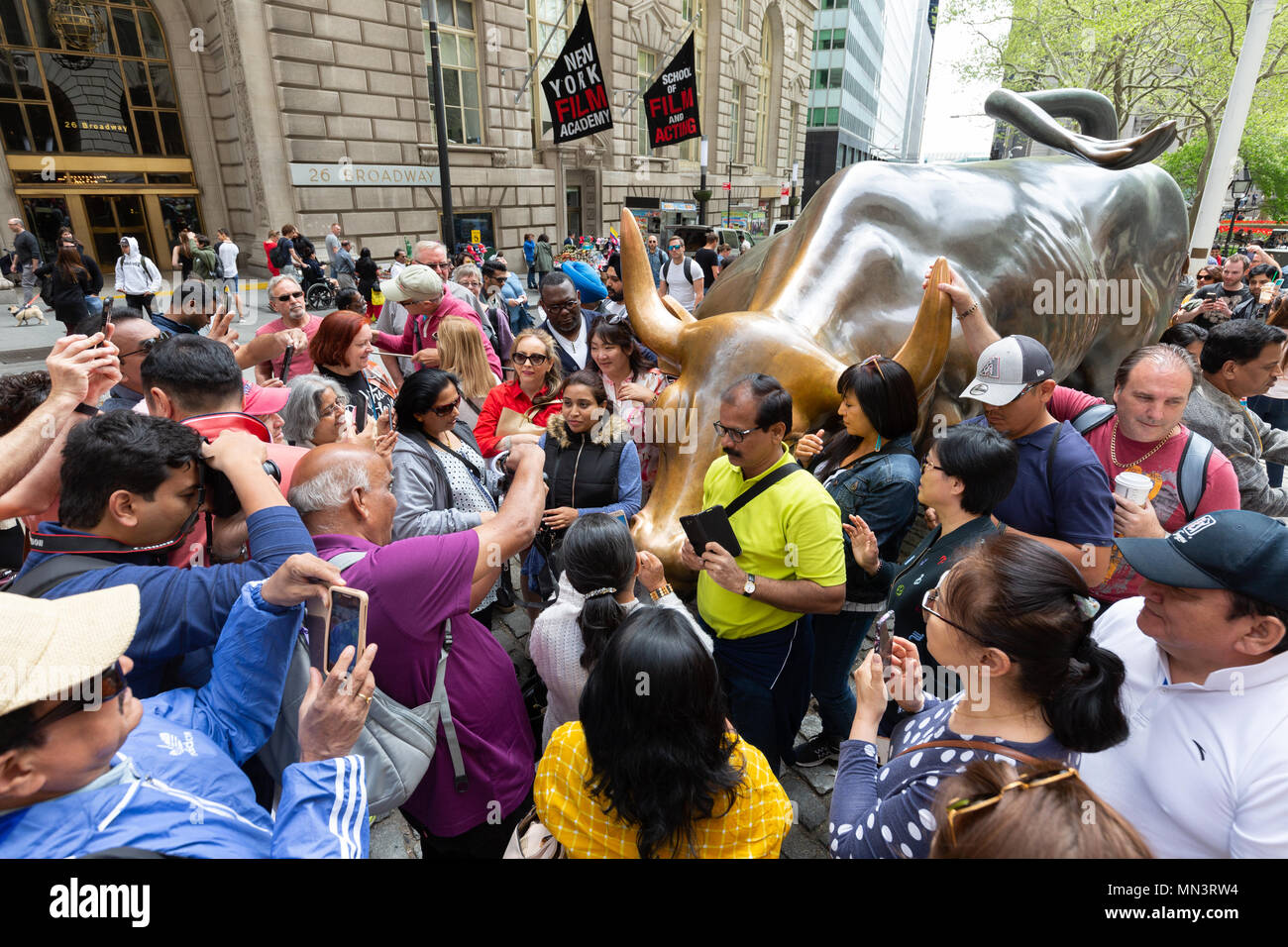 Crowds of tourists taking photos around the Wall street bull, or Charging Bull, by Arturo Di Modica, Downtown New York City, USA Stock Photo