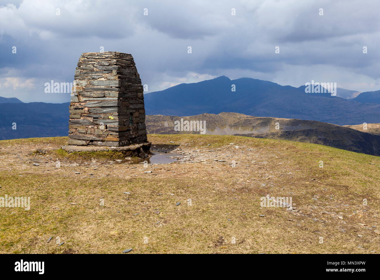 A dark and shadowy Snowdon can be seen from the Trig Point that stands on the summit of Moelwyn Mawr Stock Photo