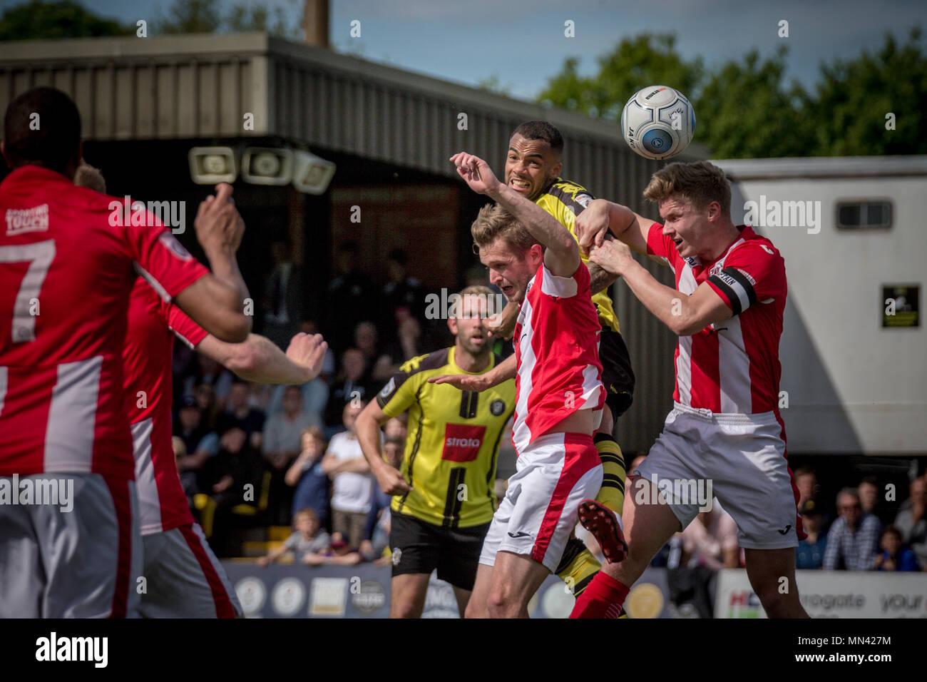 Harrogate, Yorkshire, UK. 13th May, 2018. News: Harrogate Town Promoted to the National League, The CNG Stadium, Harrogate North Yorkshire, UK. 13 May 2018.   Warren Burrell (Harrogate Town) gets a header towards goal while under pressure from the Brackley Town defenders.  Gareth Dean (Brackley Town) captain fails to get to the ball crossed from a corner.  Harrogate Town 3-0 Brackley Town - National League North playoff final at the CNG Stadium in Harrogate. Harrogate are promoted to the National League for the 2018/19 season. Credit: Caught Light Photography Limited/Alamy Live News Stock Photo