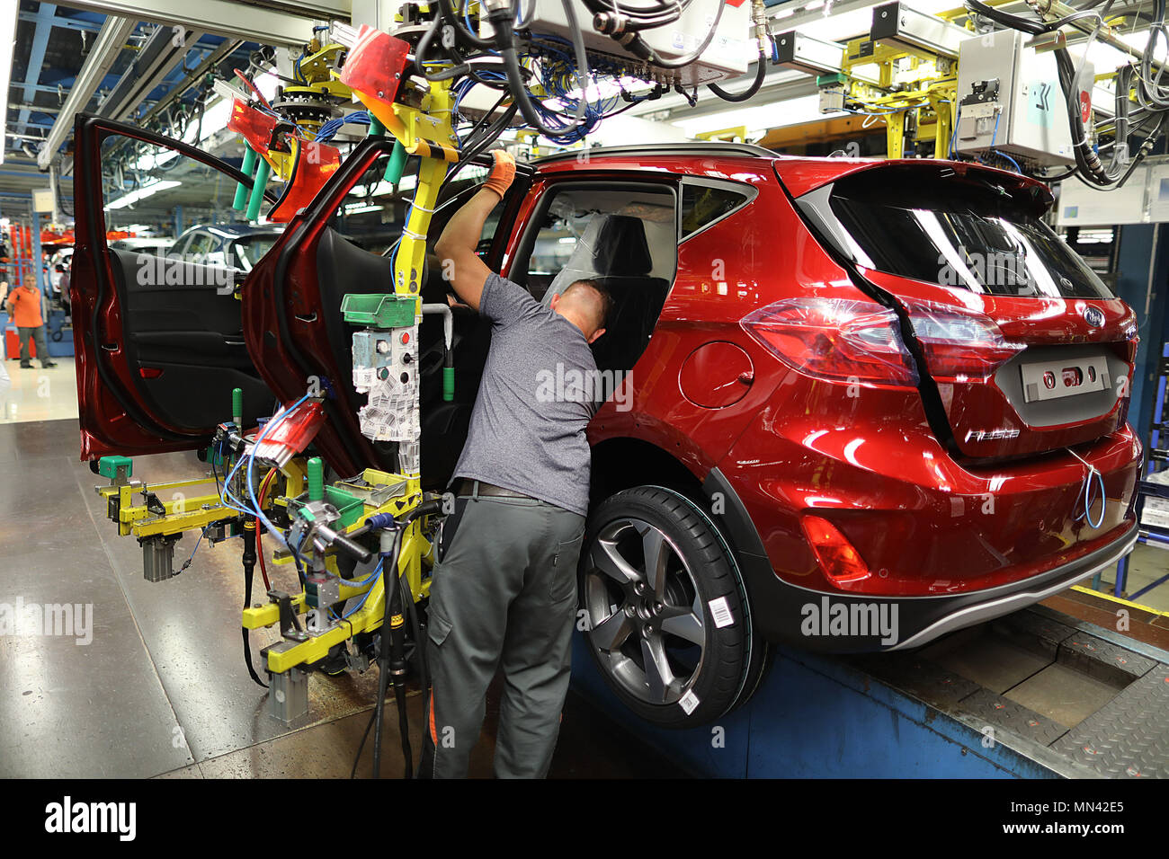 09 May 2018, Germany, Cologne: A Ford employee mounts a door of a Ford Fiesta on the conveyor belt. Photo: Oliver Berg/dpa Stock Photo