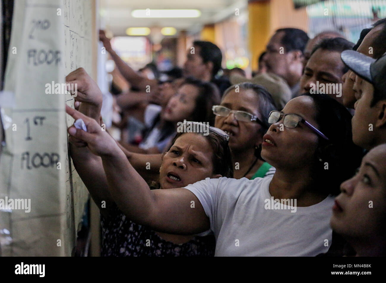 Quezon City, Philippines. 14th May, 2018. Voters search their precinct and room numbers at Pres. Corazon Aquino Elementary School in Bataasan Hills. Millions of Filipino voters flock to schools turned into voting centers nationwide for the Baragay and Sangguniang Kabataan elections. Credit: Basilio H. Sepe/ZUMA Wire/Alamy Live News Stock Photo