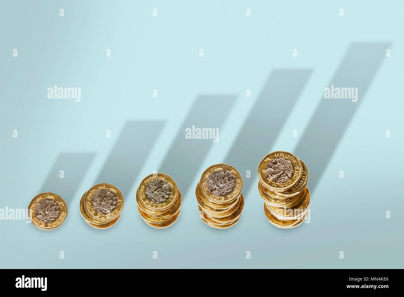 Ascending stacks of pound coins with bar graph growth shadow Stock Photo