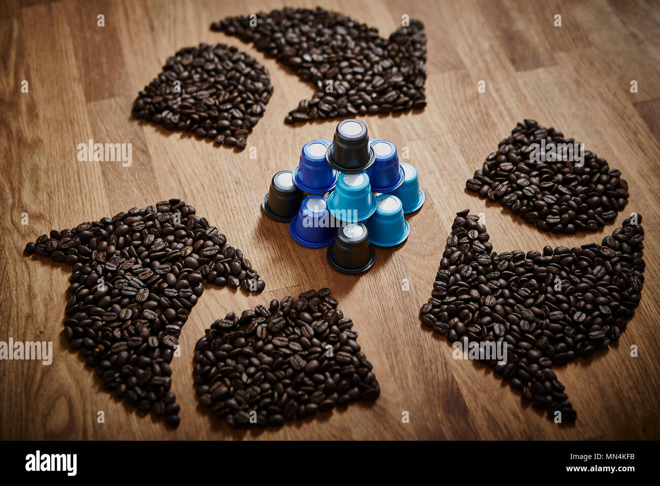 Coffee beans forming recycle symbol around plastic coffee pods Stock