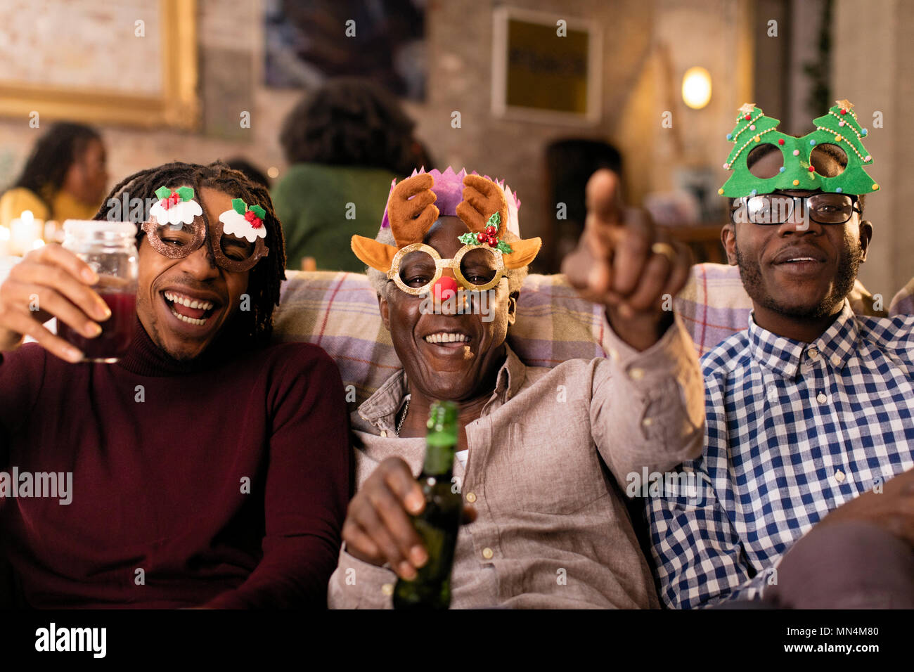 Portrait playful grandfather and grandsons wearing Christmas costume goggles Stock Photo