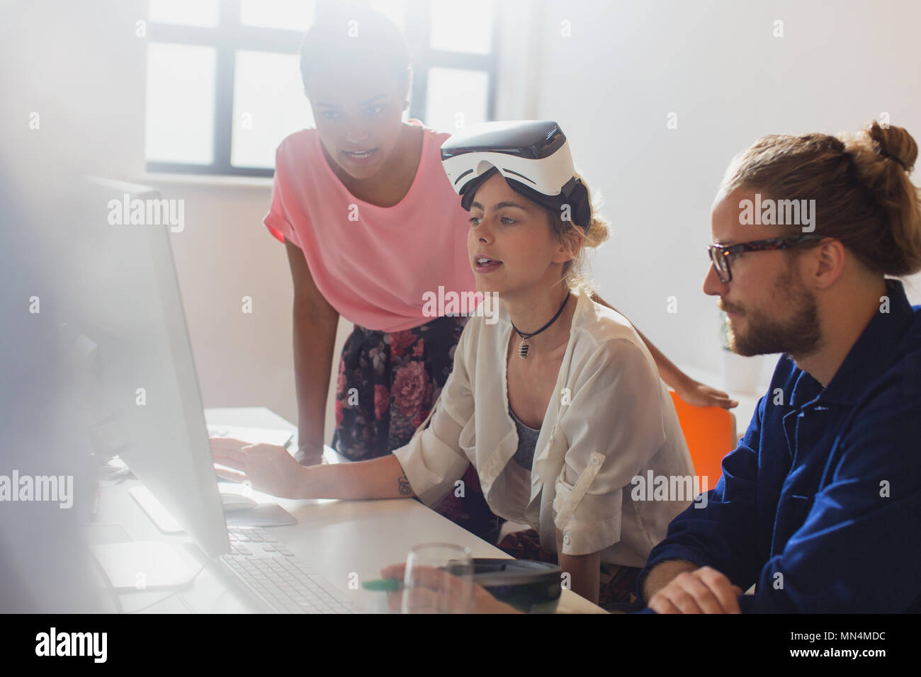 Computer programmers programming virtual reality simulator glasses at computer in office Stock Photo