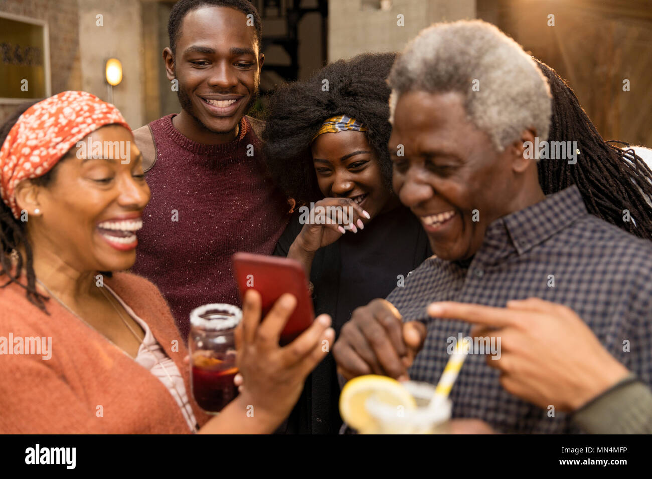 Happy multi-generation family laughing, using smart phone Stock Photo