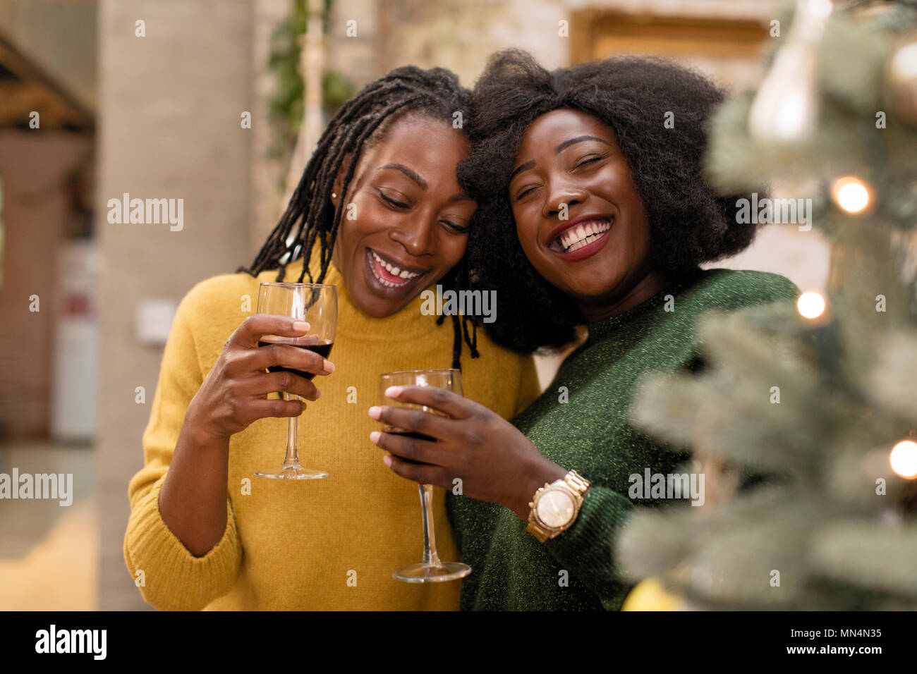 Portrait smiling, happy mother and daughter hugging, drinking wine Stock Photo