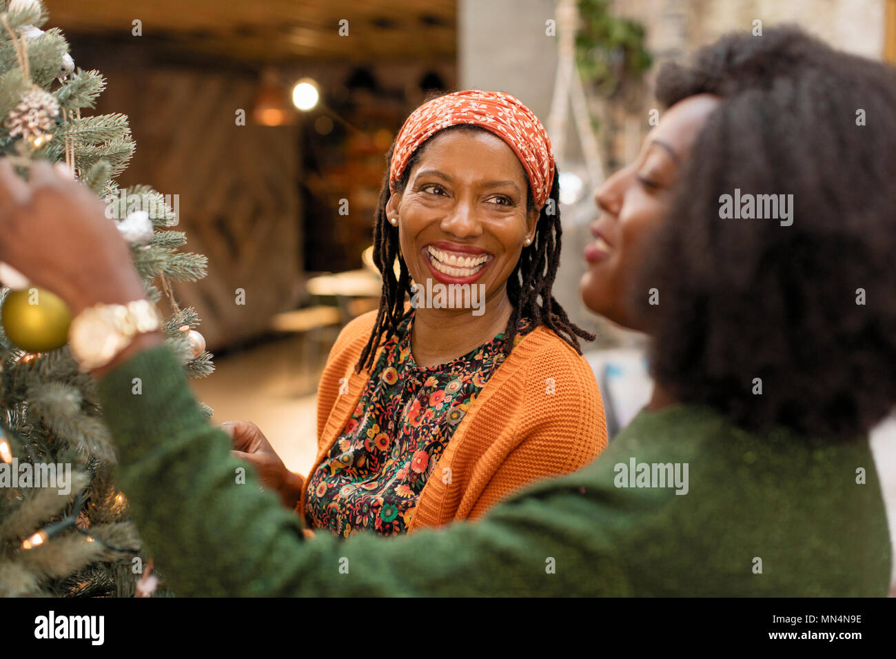 Smiling mother and daughter decorating Christmas tree Stock Photo