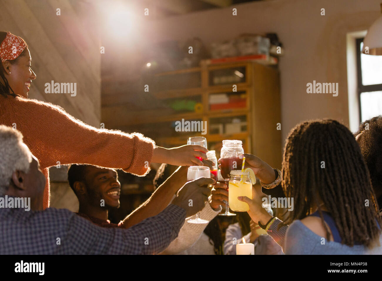 Family toasting lemonade and sangria glasses at dinner party Stock Photo