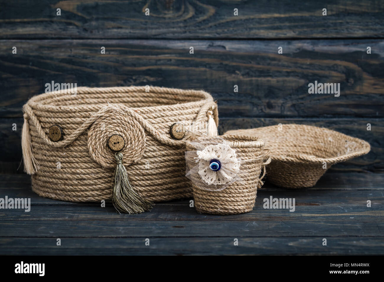 Handmade dekoratif baskets made of thick jute rope on wooden background  Stock Photo - Alamy