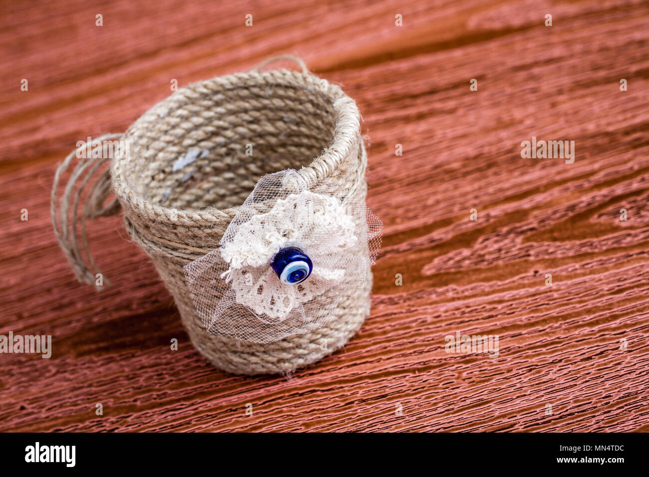 Handmade dekoratif basket made of thick jute rope on wooden