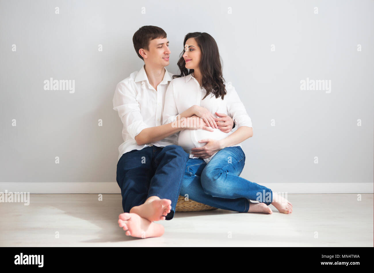 Portrait of the pregnant woman and young man together indoors Stock ...