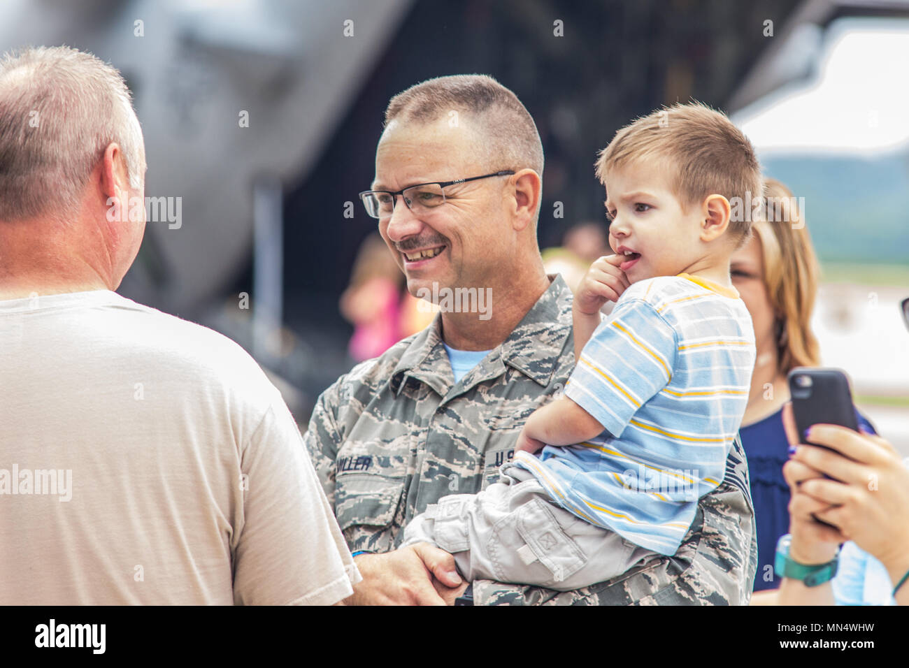 U.S. Air Force Chief Master Sgt. Randy Miller, command chief master sergeant of the 139th Airlift Wing, Missouri Air National Guard, holds his grandson, during a Family Fun Day, at Rosecrans Air National Guard Base, St. Joseph, Mo., July 6, 2017. The event was held for family members of Airmen assigned to the 139th Airlift Wing, Missouri Air National Guard. The Family Fun Day was hosted by the 139th Airmen and Family Readiness program, which included carnival rides, a petting zoo, dunk tank and more. (U.S. Air National Guard photo by Staff Sgt. Patrick Evenson) Stock Photo