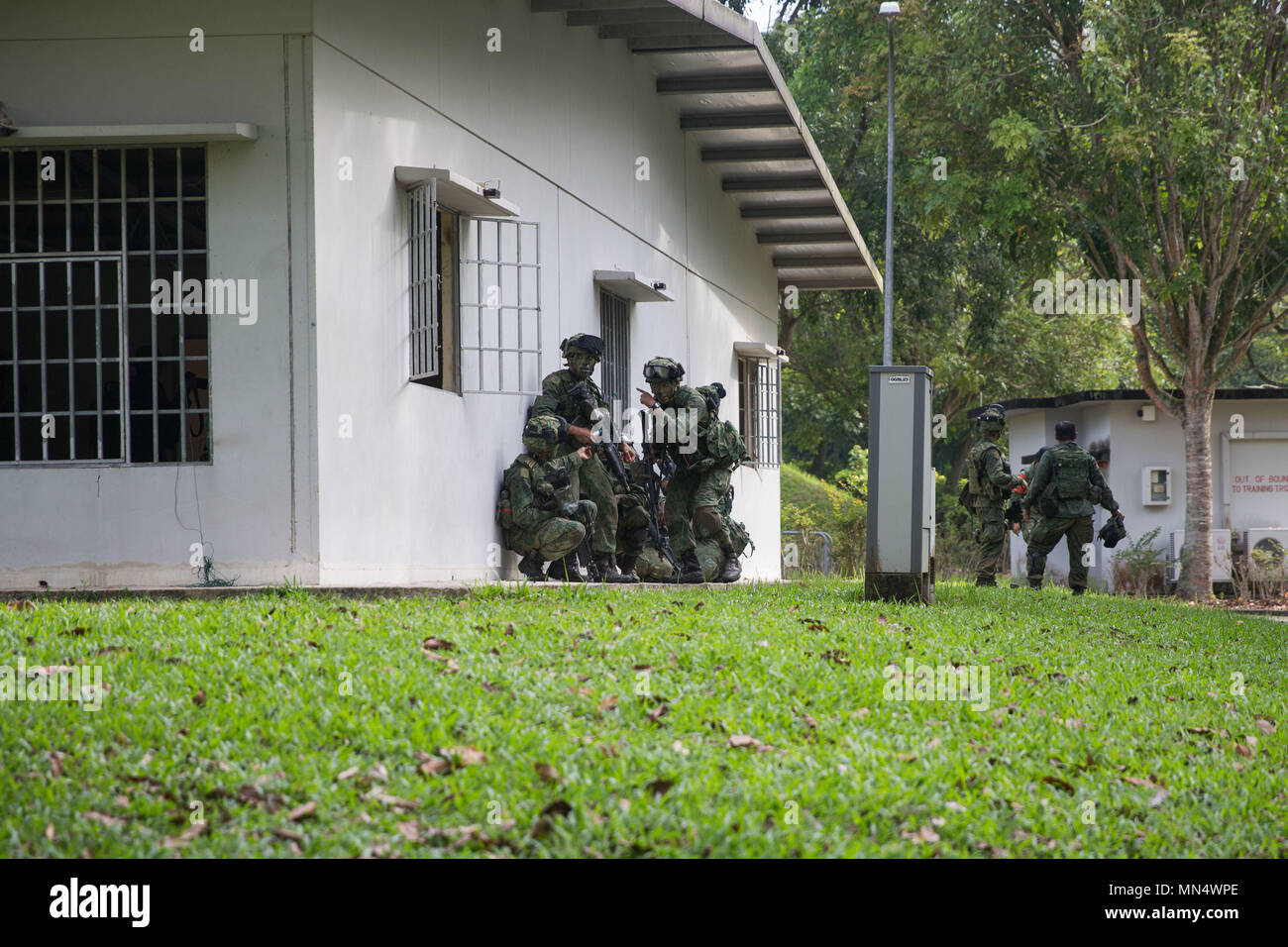 Singapore Armed Forces Soldiers clear a nearby building during a deliberate attack on urban terrain for the final exercise of Exercise Valiant Mark at Pasir Laba Camp, Singapore on Aug. 31, 2017. The purpose of the annual exercise is to enhance interoperability of our military forces and continue to build our bilateral defense relationship with Singapore. (U.S. Marine Corps photo by Cpl. Chelsey K. Courtney) Stock Photo