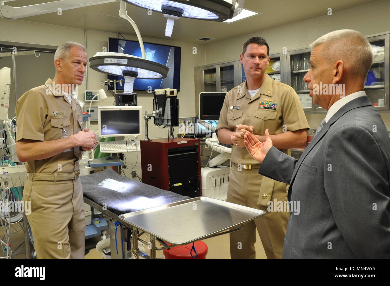Rear Adm. Paul D. Pearigen, Commander, Navy Medicine West and Chief of the Medical Service Corps (left) and Naval Medical Research Unit – San Antonio (NAMRU-SA) Science Director, Sylvain Cardin, Ph.D. discuss the unique poly-trauma injury model system developed and validated by Cmdr. Jacob J. Glaser (center) and his team at NAMRU-SA during a recent visit. NAMRU-SA researchers are at the forefront in testing combinations of FDA-approved therapeutics to stabilize patients, pre-hospital and during transport. (Photo courtesy of NAMRU-SA Public Affairs) Stock Photo