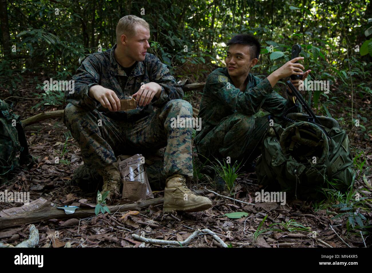 U.S. Marine Pfc. Stephen Crookston, a gunner with 1st Battalion, 3rd Marine Regiment speaks with Lance Cpl. Kevin Tan, a gunner with 3rd Battalion, Guards about the land navigation mission assigned to them during Exercise Valiant Mark on Tekong, Island, Singapore, Aug. 23, 2017. Exercise Valiant Mark builds, maintains and enhances bilateral defense and interoperability of military forces between the United States and Singapore. (U.S. Marine Corps photo by Lance Cpl. Osvaldo L. Ortega III) Stock Photo