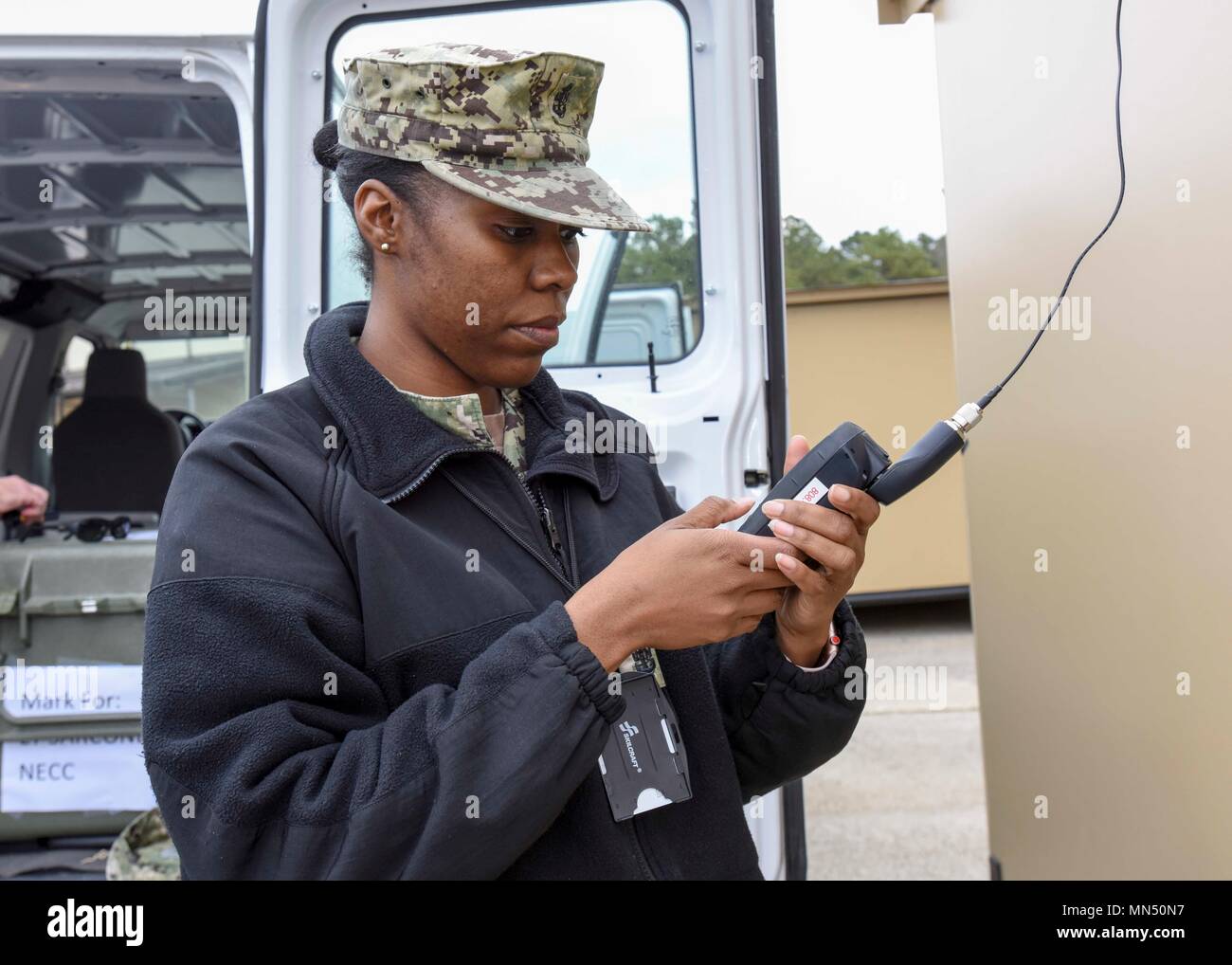 180410-N-YN937-011 VIRGINIA BEACH, Va. (April 10, 2018) – Chief Operations Specialist Sharon McQueen, from Birmingham, Alabama, assigned to Navy Expeditionary Combat Command (NECC), tests an Iridium satellite phone during NECC’s Defense Support of Civil Authorities (DSCA) scenario staff exercise on Joint Expeditionary Base Little Creek-Fort Story. DSCA events are designed to provide Department of Defense assets to civil authorities in response to requests for assistance for domestic emergencies. (U.S. Navy photo by Mass Communication Specialist 3rd Class Alan Lewis/Released) Stock Photo